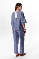 Blusa azul de lino con escote barco y mangas 3/4 con detalle de ribete blanco.