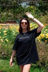 Remerón negro de corte amplio con estampa de flor blanca en la espalda.