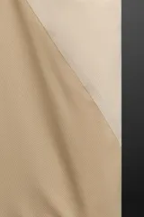 Musculosa deportiva color beige de tejido técnico ligero y elástico con estructura perforada. Tiene cuello redondo amplio, manga sisa con acabados termofijados, bajo con aberturas laterales y logo estampado.