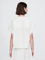 Camisa de muselina color blanco, con cuello mao y mangas cortas.