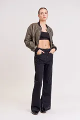 Pantalón de jean negro de corte ancho con aberturas en el ruedo y detalle de strass en la cintura y bolsillos.