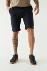 Bermuda de gabardina color beige, corte chino, con bolsillos laterales y traseros, cierre con cremallera y botón, presillas para cinturón y logo bordado.