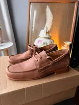 Mocasines de cuero negro con cordones finos y suela plana.