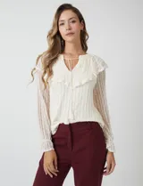 Blusa de encaje color beige de la marca Cupio, con cuello a la base y escote en V con lazo de ajuste. Presenta una sobrecapa de encaje con aplique de puntilla y mangas largas de encaje floral translúcido, terminadas en puños elásticos con volado. Incluye forro interno a tono.