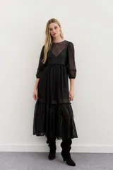 Vestido largo negro de tul bordado con lentejuelas y canutillos, mangas ballon y escote redondo.