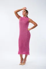 Vestido midi tejido al crochet color fucsia, con cuello alto y sin mangas.
