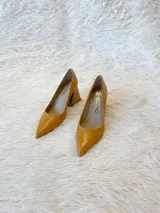 Zapatos de tacón color mostaza de cuero, con punta fina y tacón cuadrado forrado en cuero tipo madera.