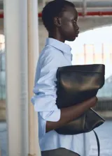 Camisa blanca entallada de algodón con cuello camisero y mangas largas con puños abotonados.