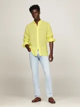 Camisa de lino color amarillo claro, de corte regular, cuello abotonado y manga larga.