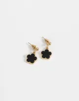 Aros colgantes cortos con pasante redondo dorado y dije de flor esmaltada negra con borde dorado.