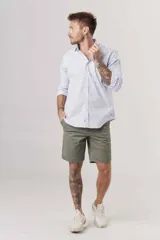 Camisa celeste a rayas verticales blancas, de corte clásico, manga larga y cuello abotonado.