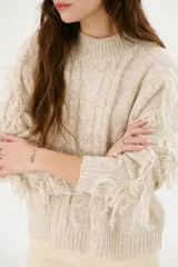Sweater color arena de tejido de punto con cuello redondo y mangas largas con flecos.