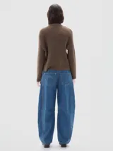 Jean de pierna ancha que se estrecha hacia el tobillo, con cintura ajustada y corte relajado en cadera y muslo. Confeccionado en denim azul con hilos dorados y tiro medio.