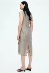 Vestido tubo color gris con cuello redondo y sin mangas. Presenta detalles decorativos de lentejuelas y cuentas brillantes.