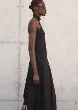 Top negro de punto fino con cuello halter y diseño entallado.