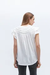 Blusa blanca de lyocell y algodón, con escote fruncido con volados y lazos.
