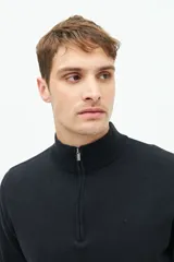 Buzo de hombre tejido color negro, con cuello alto, medio cierre frontal y logo bordado en el pecho.
