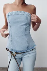 Top strapless de denim celeste con escote recto y cierre trasero con cremallera.