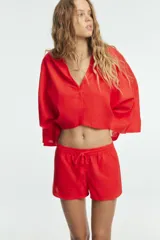 Shorts de tiro bajo color amarillo claro, confeccionado en tejido con lino. Presenta cintura elástica ajustable con cordones y aberturas laterales en el bajo.