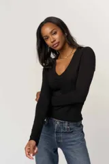 Remera de manga larga color negro, confeccionada en jersey liviano con escote en V y calce ajustado al cuerpo.