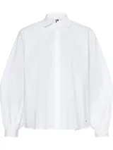 Camisa blanca de algodón orgánico con cuello inglés, corte amplio y mangas raglán abullonadas con puños abotonados.