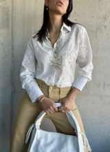 Camisa blanca de manga larga con bordado floral.