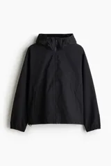 Campera rompevientos negra de nylon repelente al agua con protección UV, corte regular, cierre frontal, capucha con cordón de ajuste elástico, puños elásticos, bolsillos laterales y bolsillo interior con cierre, forro de malla y cordón de ajuste elástico oculto en el bajo.