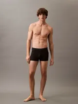 Pack de tres bóxers ajustados Calvin Klein, uno negro, uno gris y uno azul marino, con cintura elástica con logo de la marca.