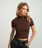 Blusa corta de rib color rosado, con cuello alto y mangas cortas.