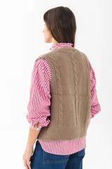 Chaleco de punto color rojo con diseño trenzado, escote en V y cierre frontal con botones.