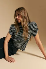 Remera de manga corta con rayas horizontales negras y blancas. Presenta cuello redondo y mangas abullonadas con frunce en los hombros.