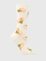 Calcetín de largo medio color crema con estampado de rodajas de limón y hojas verdes. Presenta un puño suave con borde festoneado.