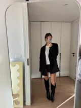 Bota texana de cuero negro con caña alta combinada en cuero liso y gamuza. Tiene taco cuadrado de 5 cm y punta fina.
