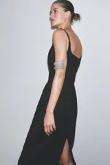 Vestido midi negro de breteles finos regulables, escote recto y abertura en el ruedo.