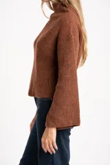 Sweater de punto acanalado color marrón, con cuello alto tipo polera y mangas largas de corte ancho. Posee un diseño oversize confeccionado en mezcla de lana.