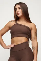 Top deportivo negro de un solo hombro, con textura acanalada y calce ajustado.