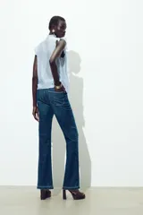 Blusa celeste sin mangas con escote en V y volantes.