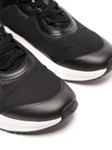 Championes deportivos Umbro modelo Sprint para mujer, color negro con detalles en blanco. Presentan una capellada de malla transpirable con refuerzos sintéticos, logo Umbro en el lateral y una suela gruesa de goma blanca con base negra.
