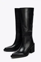 Bota de cuero negra de caña alta, con punta fina y tacón ancho.