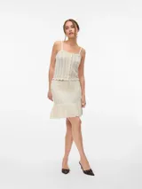 Falda tejida de algodón color crudo, con cintura elastizada con cordón ajustable y volado en el ruedo.