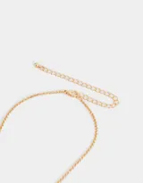 Cadena corta dorada con dije de candado en forma de corazón y llave, ambos con incrustaciones de strass.