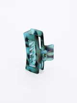Broche para el pelo tipo pinza, color celeste con manchas marrones.