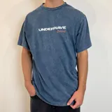 Remera azul con efecto gastado, corte holgado y estampado en el frente y la espalda con motivos surferos y el texto "Surf n' Destroy".