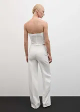 Top blanco strapless con diseño fruncido y maxi flor en el lateral.