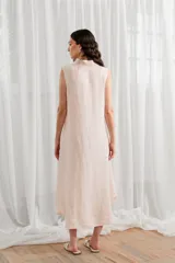 Vestido túnica midi sin mangas, color blanco, con cuello camisero y cierre frontal con botones.