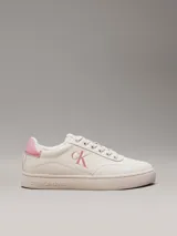 Zapatillas bajas Calvin Klein Jeans color crema con logo CK rosado en el lateral y detalle rosado en el talón.