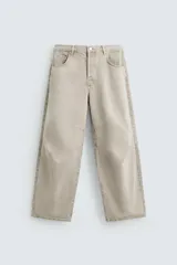 Pantalón de jean color beige, de corte amplio y tiro alto, con cinco bolsillos, efecto lavado y cierre frontal con botones.