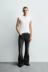 Pantalón de jean celeste, de tiro medio, corte ajustado en la parte superior y acampanado desde la rodilla. Tiene cinco bolsillos, efecto lavado y bajo irregular.