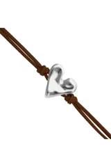 Pulsera ajustable con cordón de cuero marrón y un dije central de corazón plateado con acabado martillado. Cuenta con un cierre corredizo de bola metálica plateada.