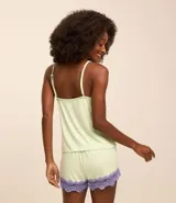 Conjunto de pijama color verde claro, compuesto por un top de breteles finos con escote en V y encaje color lila, y un short con cintura elástica y encaje lila en el ruedo.